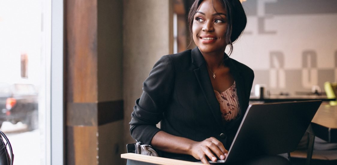 African american business woman working on a computer in a bar